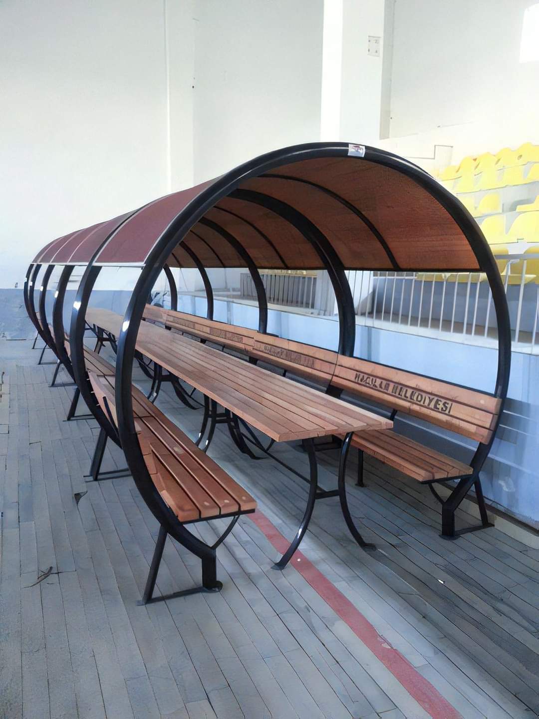 Circular arch iron covered bench seating installed at a stadium