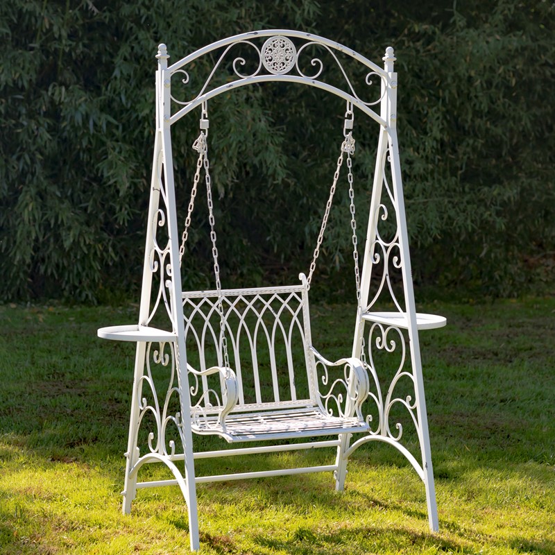 Elegant white Victorian-style iron arch garden swing on lawn