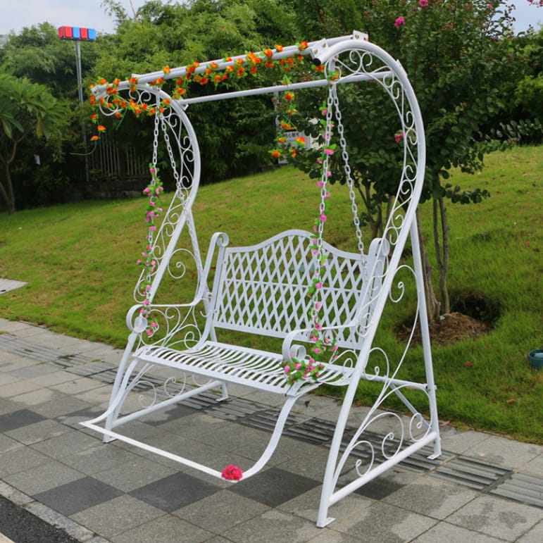 White ornate wrought iron garden swing